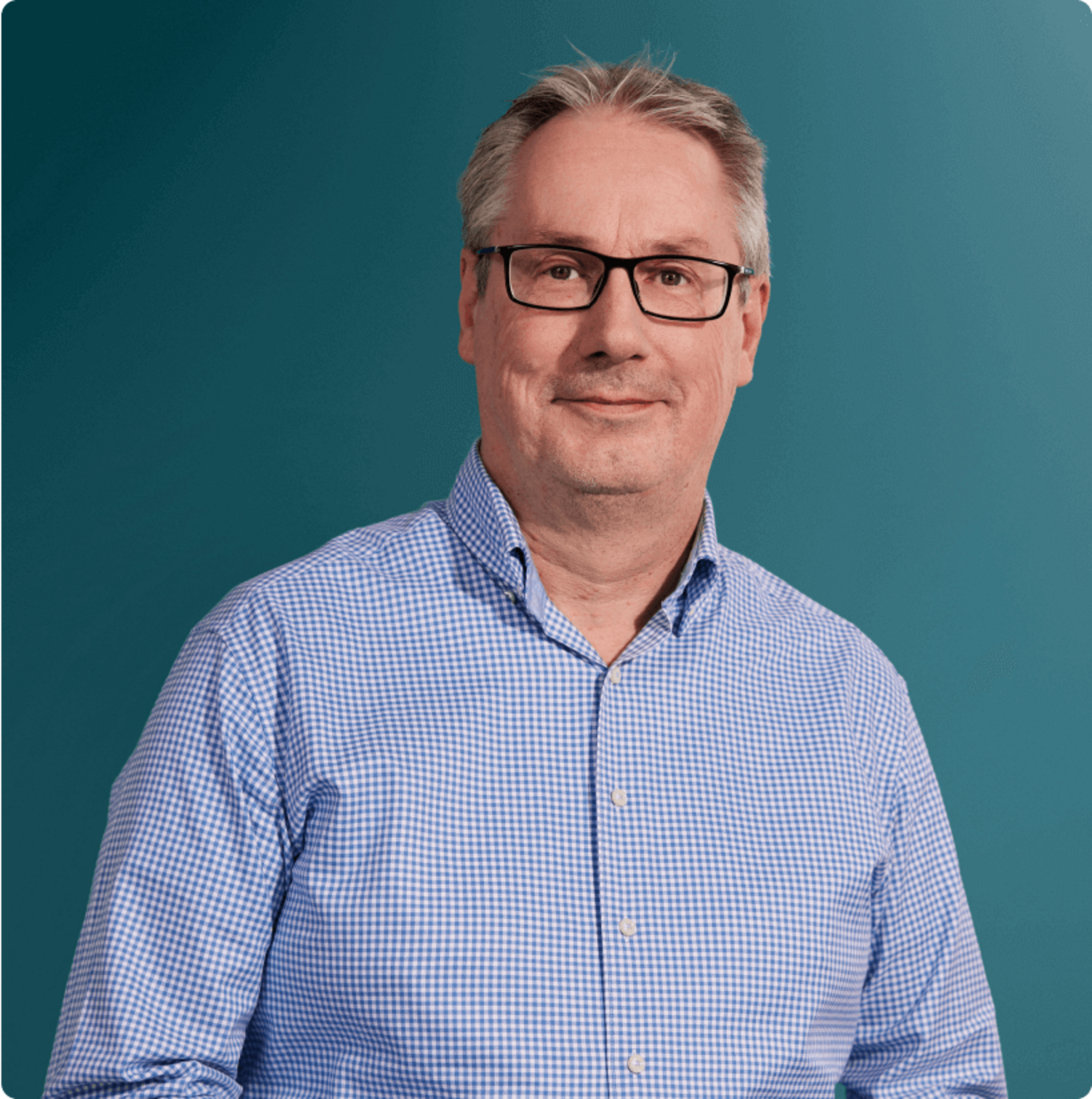 Ansprechpartner für Glasfaser bei OXG, lächelt vor einem einfarbigen Hintergrund
