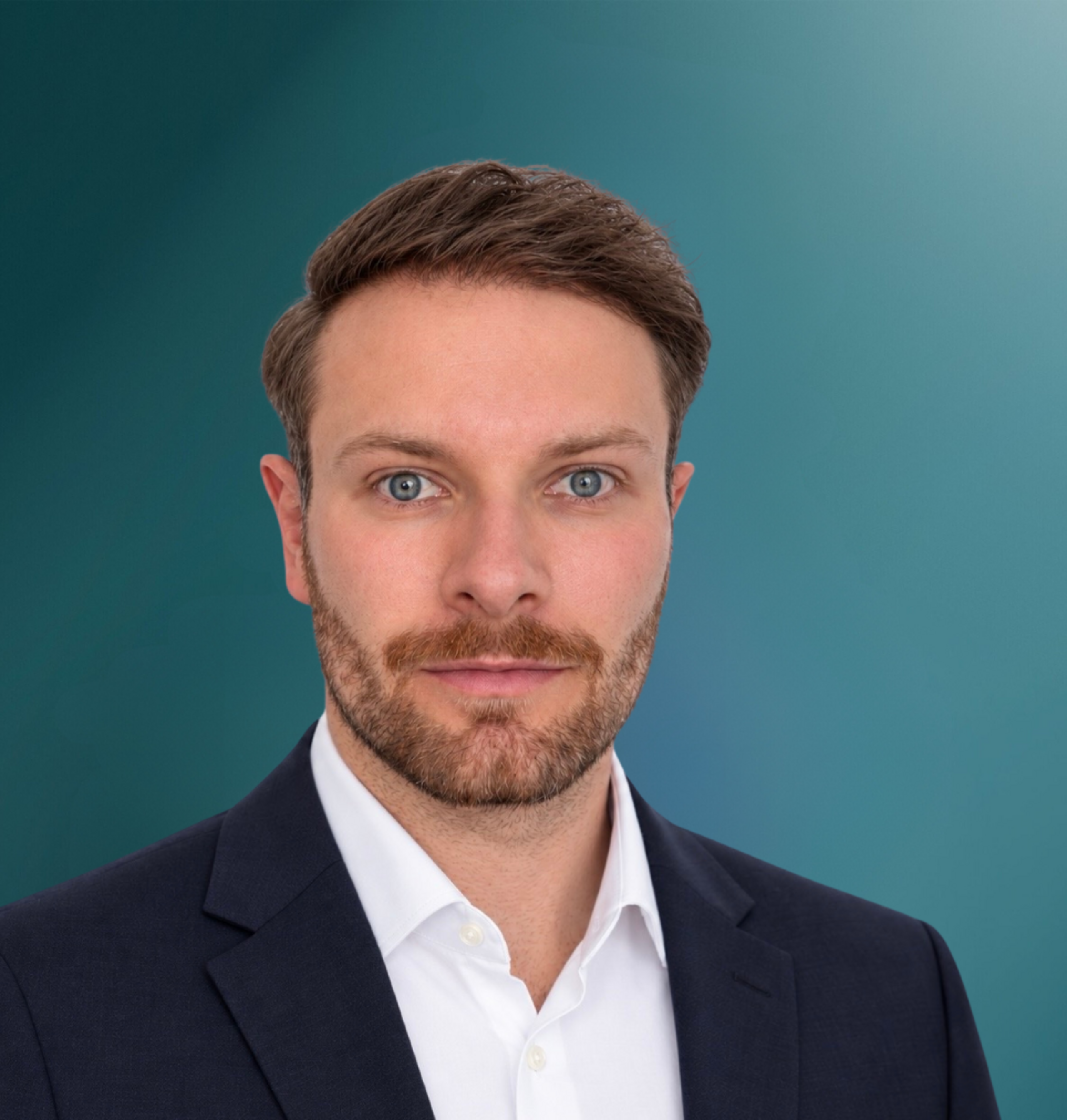 Ein junger Mann trägt einen Anzug und ein weißes Hemd vor einem einfarbigen Hintergrund