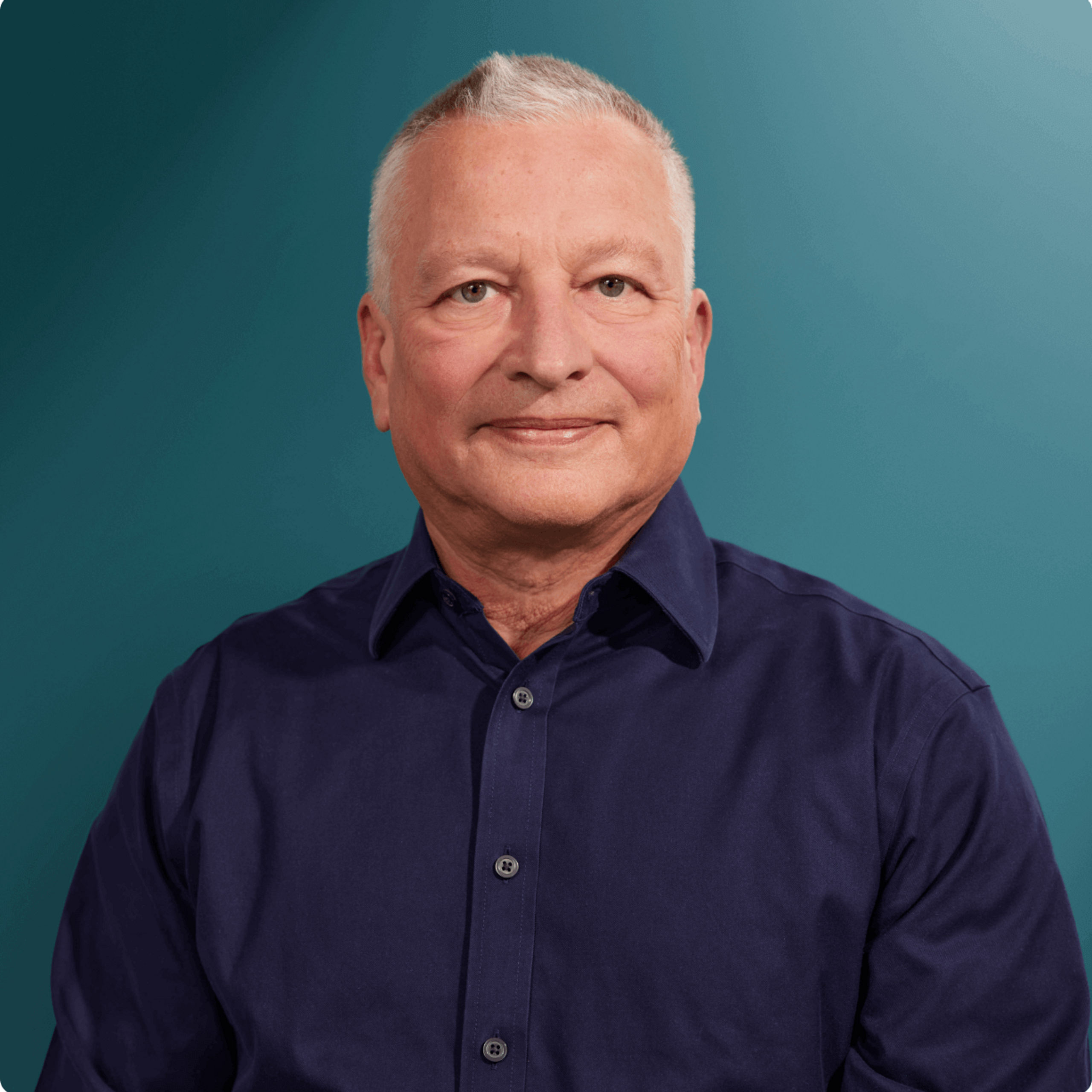 Hartmut Kühn, Ansprechpartner für den OXG Glasfaserausbau in Kommunen, mit freundlichem Blick in blauer Hemdfarbe vor einem hellen Hintergrund