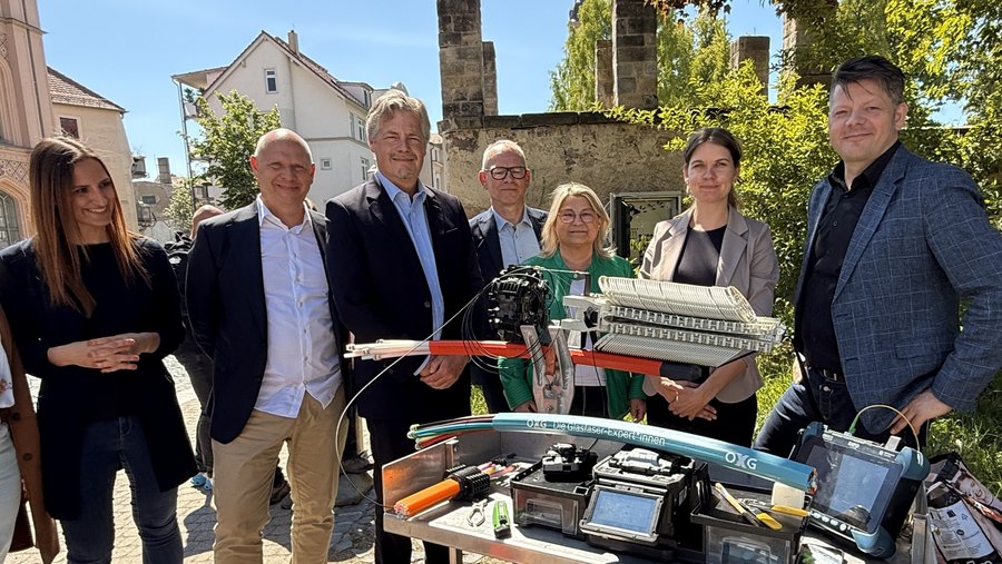 Gruppenaufnahme von Fachleuten, die zusammen mit Glasfasertechnik und -geräten im Freien in der Stadt Zittau stehen